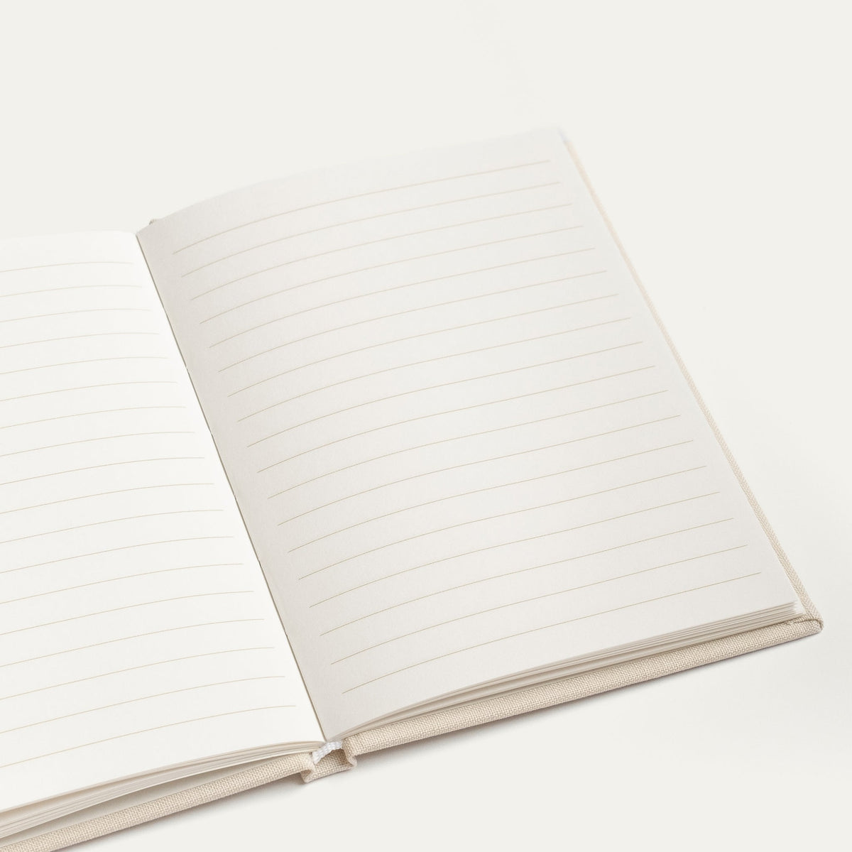 Open ivory vow book showing blank lined pages