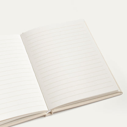 Open ivory vow book showing blank lined pages
